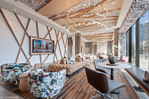 A modern living room with a large floral chair and a chandelier.