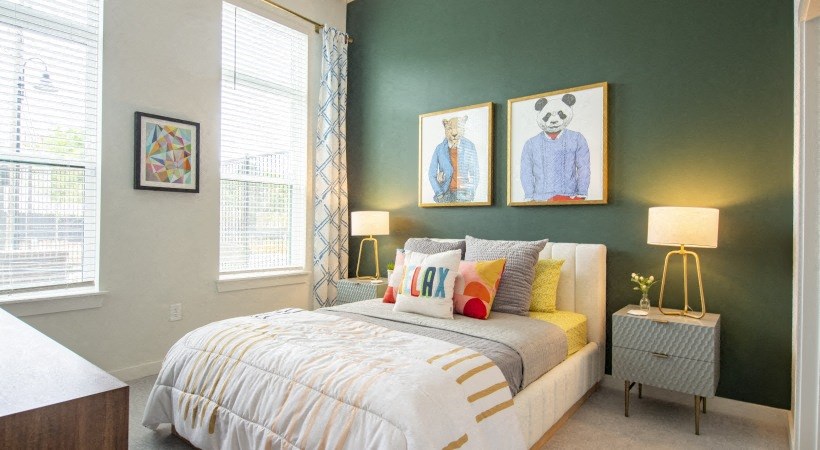 a bedroom with a bed and two paintings on the wall