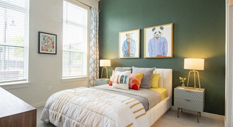 a bedroom with a bed and two paintings on the wall