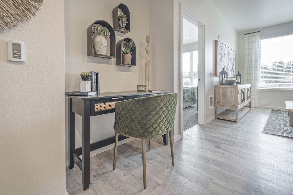 a living room with a desk and a staircase