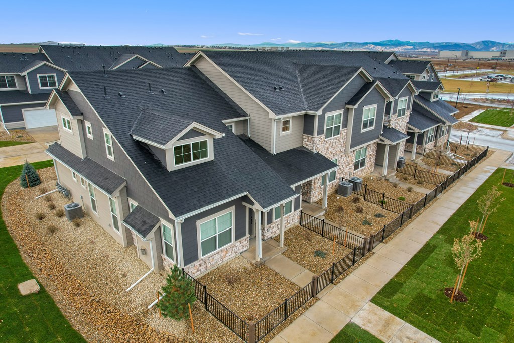 an aerial view of a row of houses with a yard