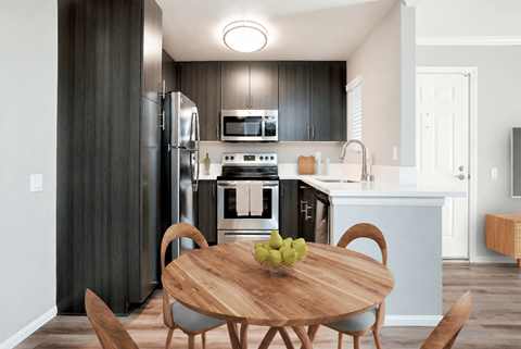 A modern kitchen with a wooden table and chairs.
