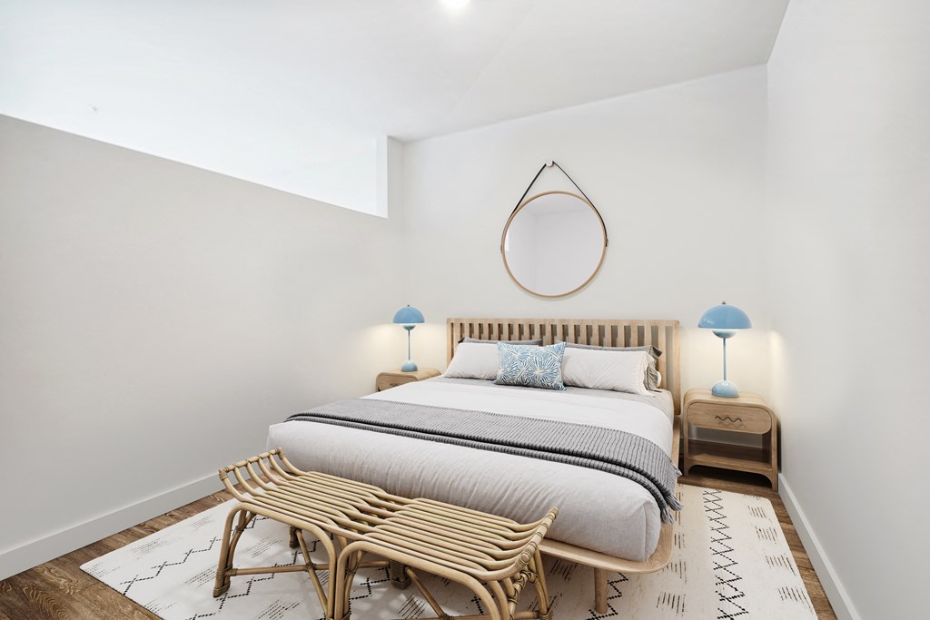 a bedroom with a bed and a mirror on the wall