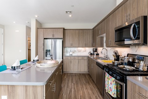 A modern kitchen with wooden cabinets and a black stove top oven.