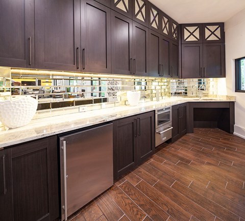 A kitchen with dark wood cabinets and a marble countertop.