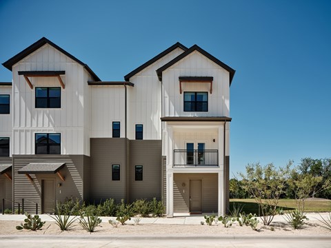 A modern two-story house with a balcony and a garage door.
