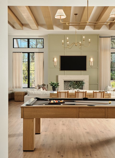 A living room with a pool table and a fireplace.