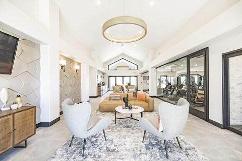 A modern living room with a large rug and two chairs.