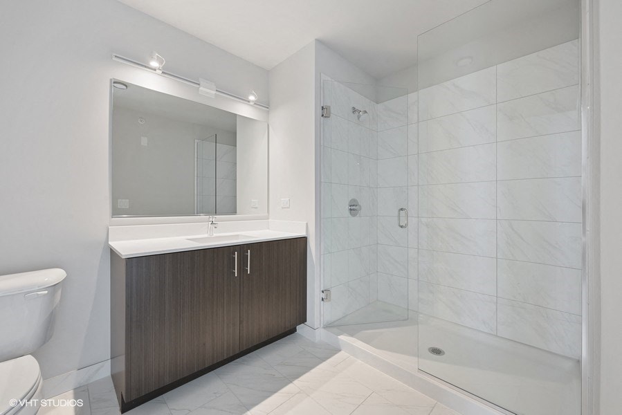 a bathroom with a shower and a sink and a mirror