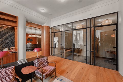 A living room with a black and red chair and a wooden floor.