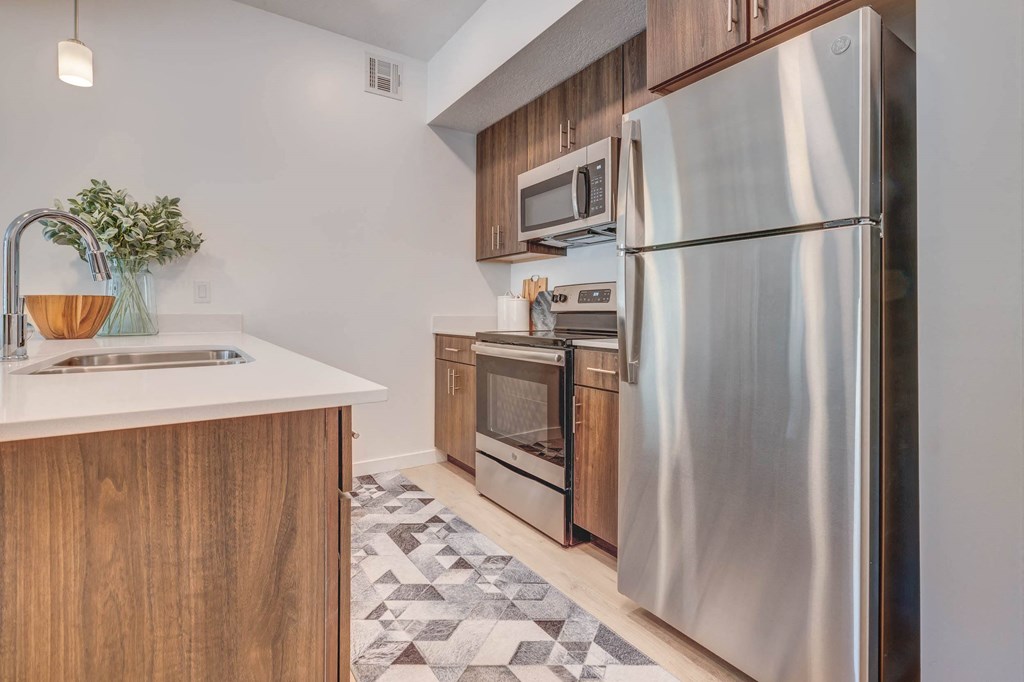 a kitchen with wooden cabinets and stainless steel appliances