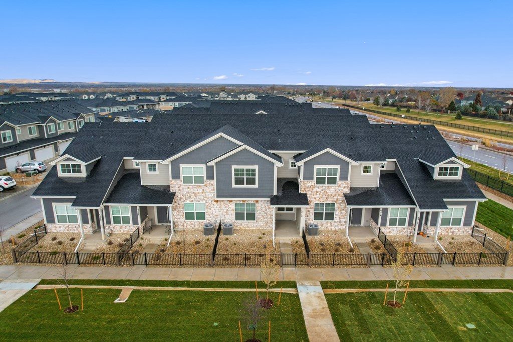 an aerial view of a large house with blue trim and green shutters