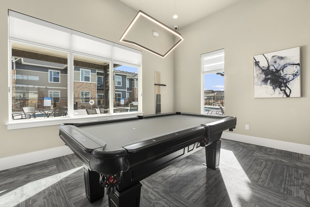 a billiards room with a pool table and a large window