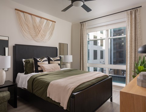 A bedroom with a large bed and a ceiling fan.