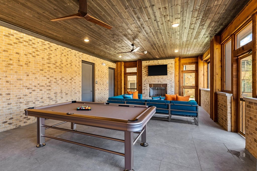 gather around the pool table to play a game of pool