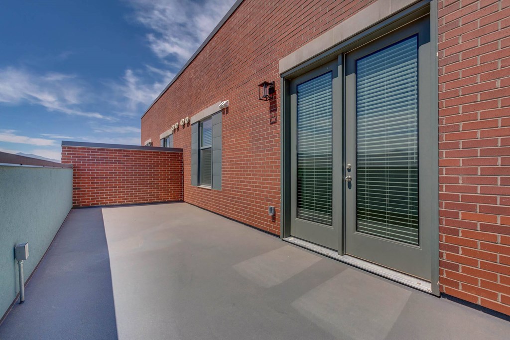 a large patio with a brick wall on the side of a building