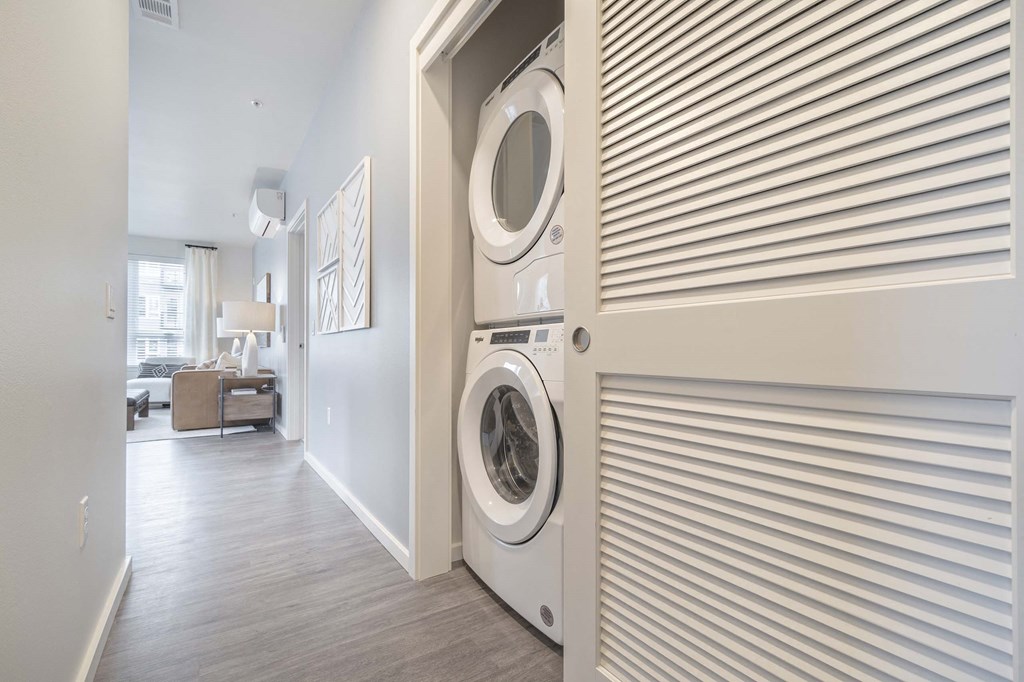 a washer and dryer in a hallway with a door