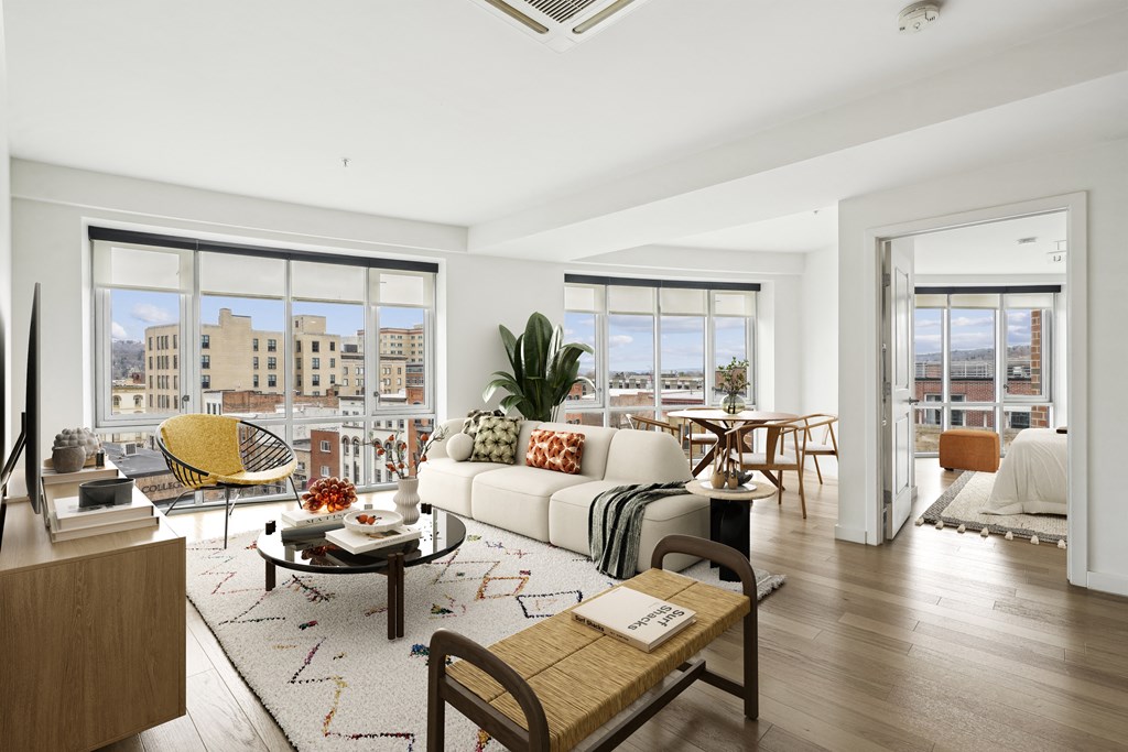 a living room with a white couch and a rug and large windows