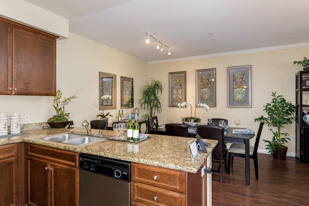 A kitchen with brown cabinets and a granite countertop.