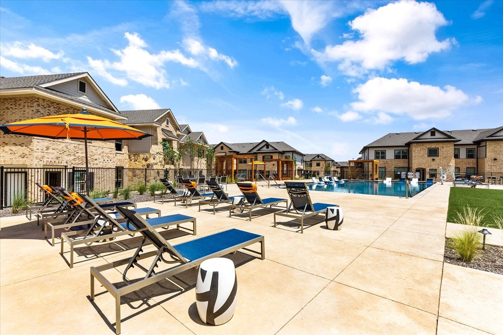 a swimming pool with chaise lounge chairs and umbrellas