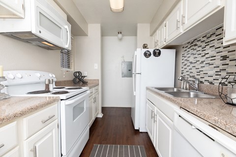 A kitchen with white appliances and cabinets.