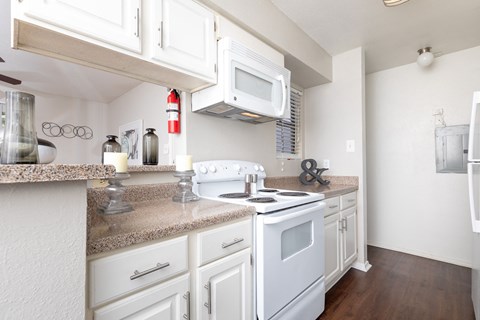 A kitchen with white appliances and cabinets.