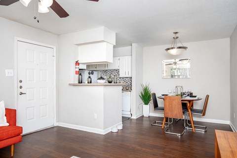 A kitchen with a red chair and a wooden table.