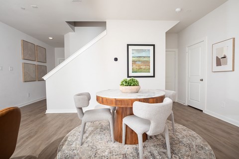A dining room with a round table and chairs.