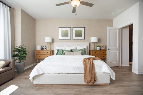 A bedroom with a large bed and a ceiling fan.