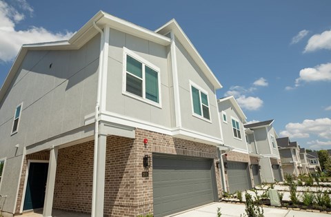 A modern house with a grey exterior and a brick chimney.