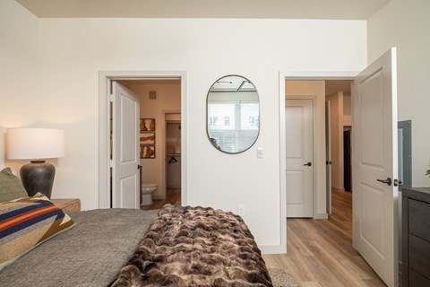 A bedroom with a bed and a mirror on the wall.
