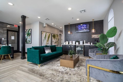 A modern living room with a green couch and a grey armchair.