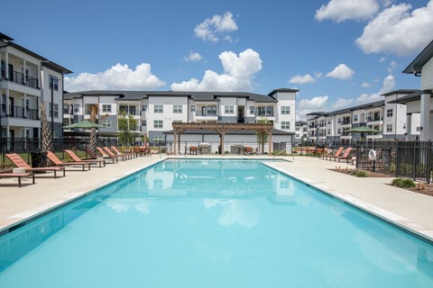 A large swimming pool in front of apartment buildings.