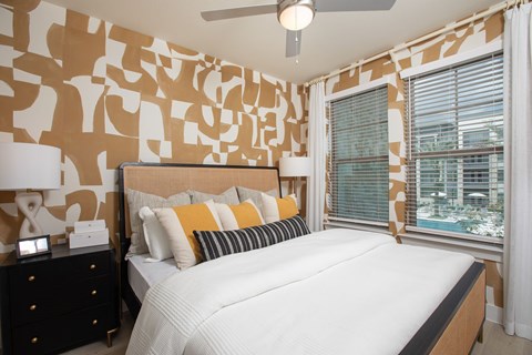A bedroom with a large bed and a ceiling fan.