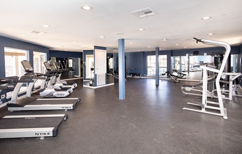 A spacious gym with treadmills, elliptical machines, and other exercise equipment.