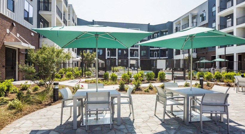 a patio with tables and chairs and umbrellas