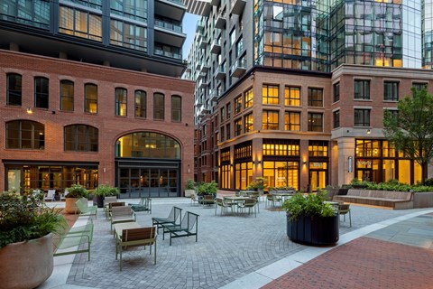 A courtyard with tables and chairs surrounded by buildings.