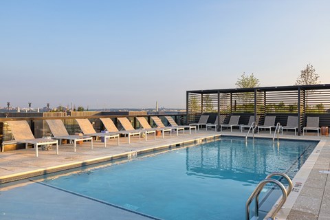 A large outdoor swimming pool with sun loungers.