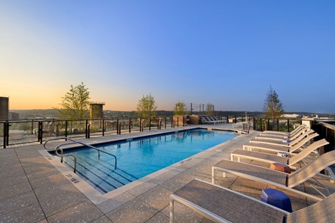 A pool with sun loungers and a view of the horizon.
