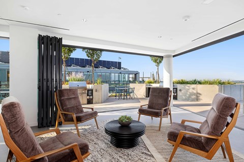 Four chairs are arranged around a table in a room with a view of the outside.