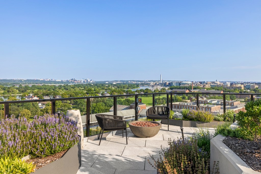 A patio with a table and chairs overlooking a city skyline.