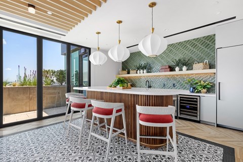 A kitchen with a bar area and chairs.