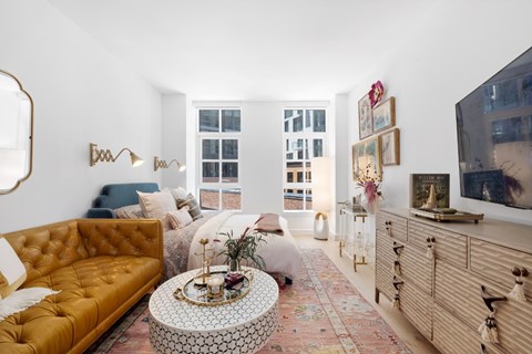 A living room with a yellow sofa and a coffee table with a floral pattern.
