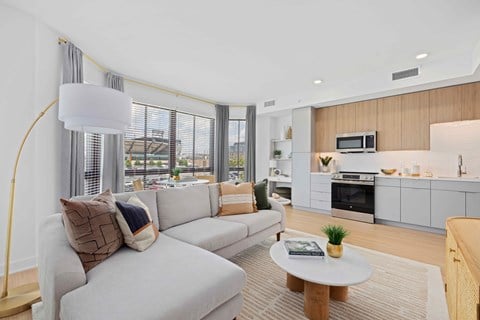 A modern living room with a grey sofa and a wooden coffee table.