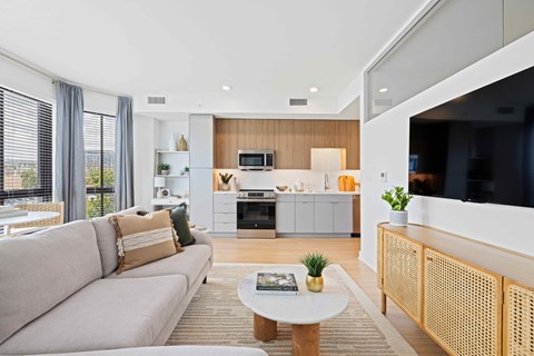 A modern living room with a grey sofa and a white coffee table.