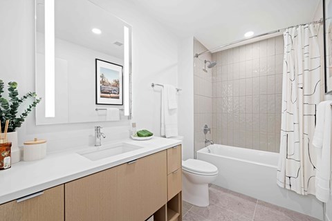 A white bathroom with a white toilet, sink, and bathtub.