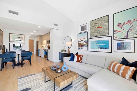A living room with a white couch, a coffee table, and a large mirror.