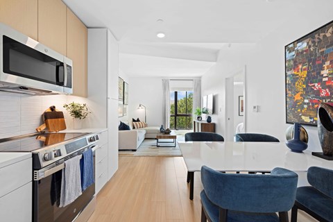 A modern kitchen with a dining area and a living room.