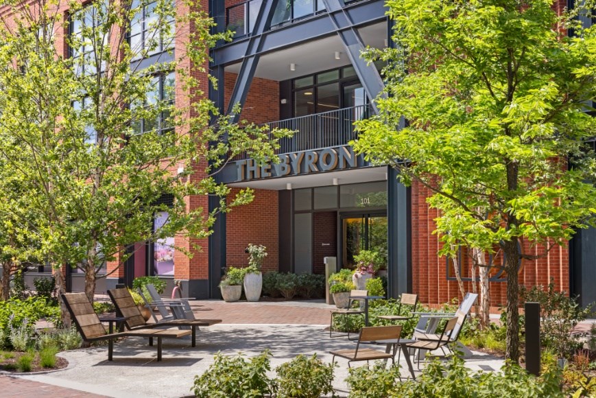 The front of a building called The Byron with a garden in front.