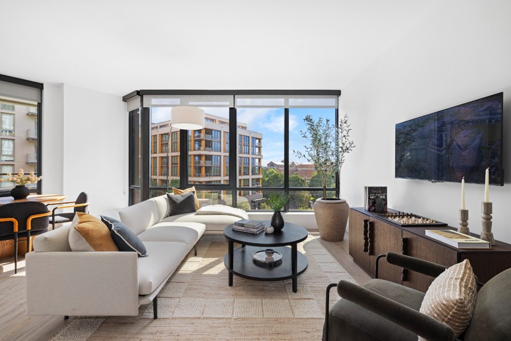A modern living room with a large window overlooking the city.